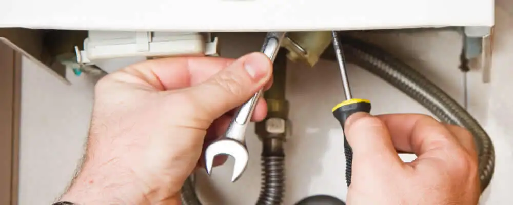 Boiler repair technician tightening pipe fittings and connections in Bradenton, FL