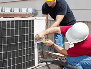 HVAC technicians repairing an outdoor AC unit on a rooftop in Bradenton, FL