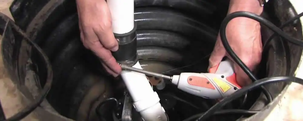 Sump pump installation technician connecting PVC discharge piping in Bradenton, FL