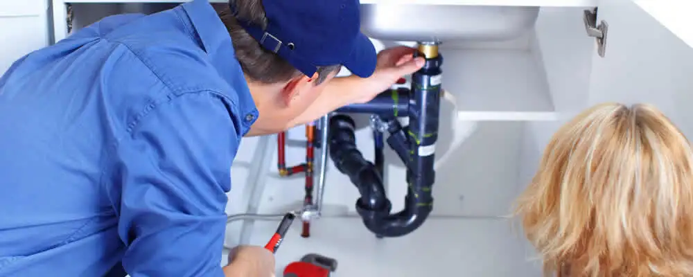 Plumber repairing under-sink drain pipes and fittings in Bradenton, FL